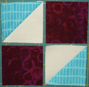 Sew a red violet square to a half square triangle.