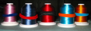 A pony tail holder keeps threads wound around the spool.
