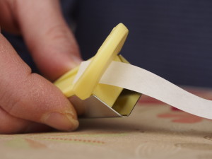 Feed the fusible tape through the top opening with the paper side up