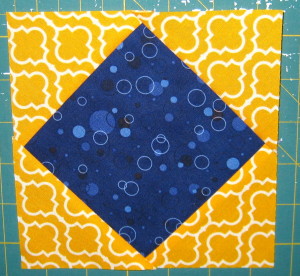 Sew remaining 2 yellow-orange triangles on to make a larger square