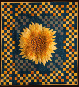 The stitched squares on the background connect the border with the sunflower