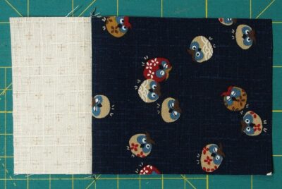 Easy three fabric block with a cream rectangle sewn to a small blue rectangle