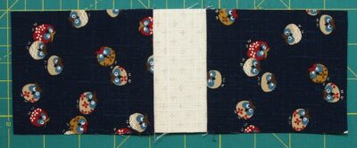 Easy three fabric block with two small blue rectangles sewn on either side of a small cream rectangle