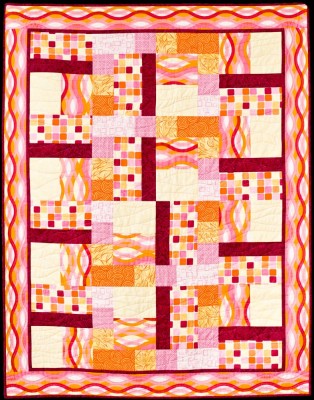 A beginner patchwork quilt in orange and pink