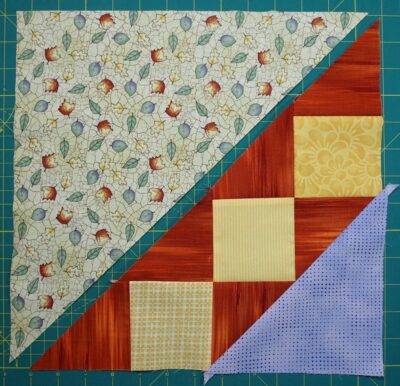 purple triangle sewn to the squares and triangles