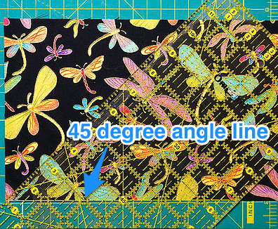 Align the 45 degree angle line with the bottom edge of the fabric