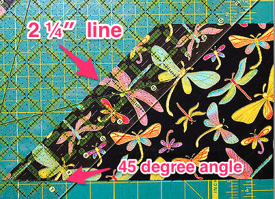 Align the 2 ¼″ line of the ruler with the diagonal edge of the fabric to cut strips