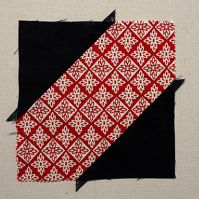 black triangles sewn to red piece of fabric