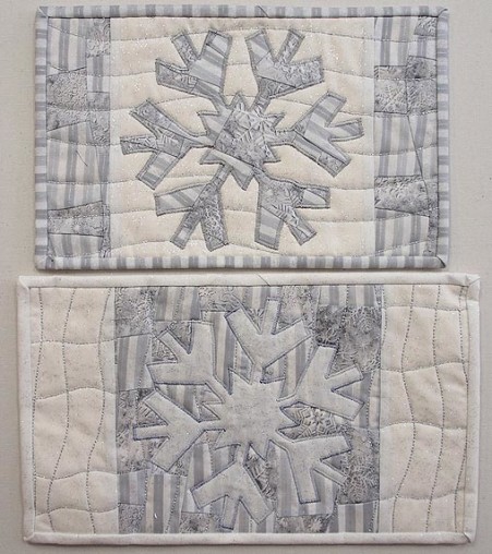A pair of snowflake mug rugs