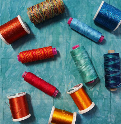 Variety of thread on teal fabric