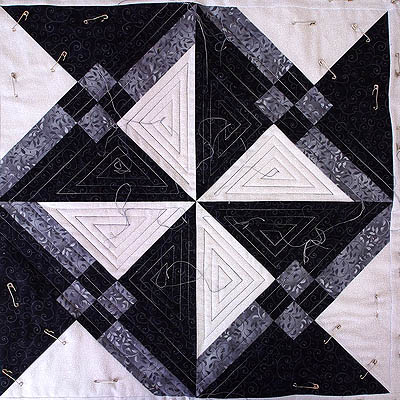 The square encompassing the pinwheel is quilted with a straight line