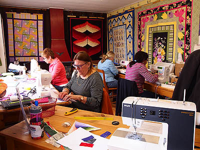 Quilter's busy sewing at their machines