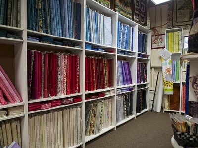 Many colourful bolts of fabric line the shelves