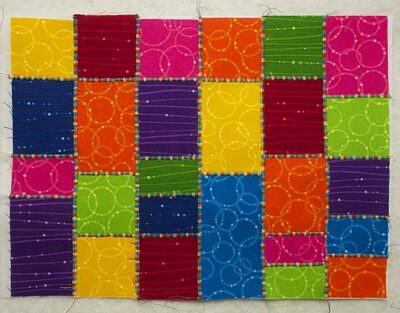 Bright coloured squares and rectangles stitched together with a zigzag stitch