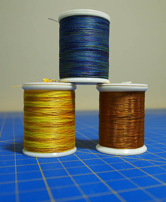 Yellow, gold and blue spools of thread