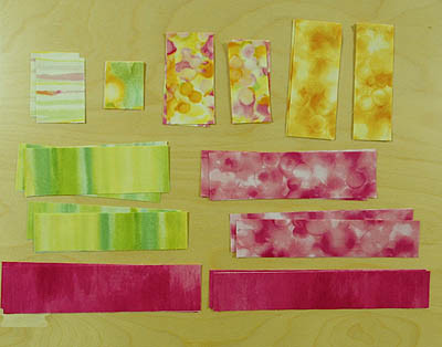 Multiple rectangles of fabric in pink, yellow, green and cream