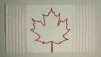 the back of the mug rug with red stitching lines on white fabric