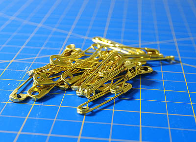 a pile of brass coloured safety pins