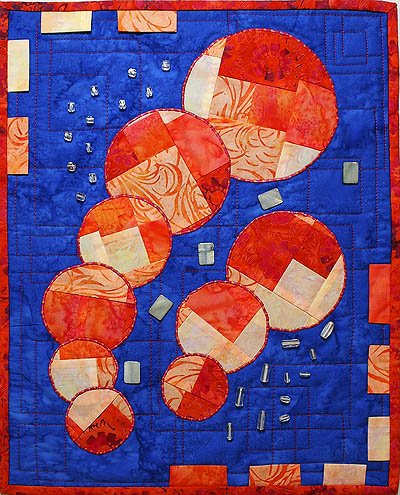 Blue and orange quilts with circles, rectangles and beads