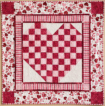 pink and white quilt with a heart centre