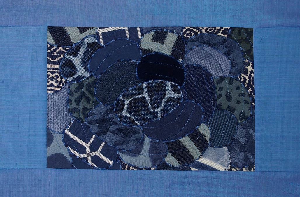 collage of blue fabrics shaped as ovals in a blue frame