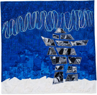 Inukshuk and northern lights art quilt on pieced background