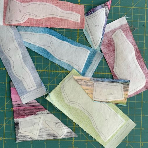 White fusible web pieces fused to coloured fabrics