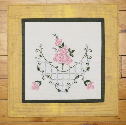yellow frame around pink and green embroidery