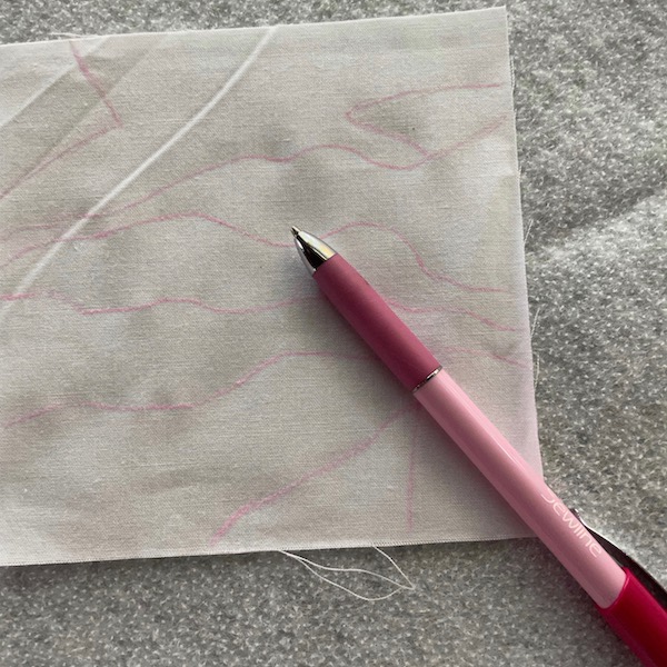 pink lines on a white square sitting on white fleece