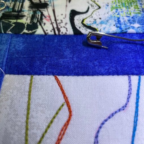 white stitching along blue fabric