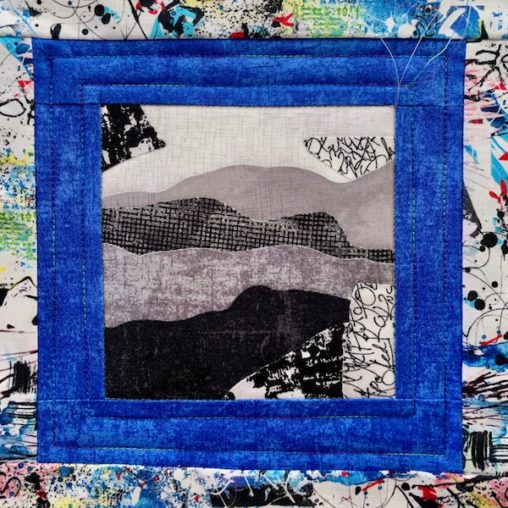 Blue sashing has two lines of quilting