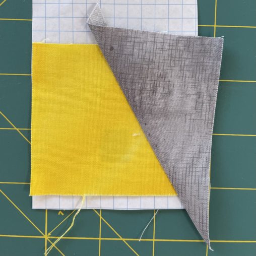Grey triangle sewn to yellow fabric