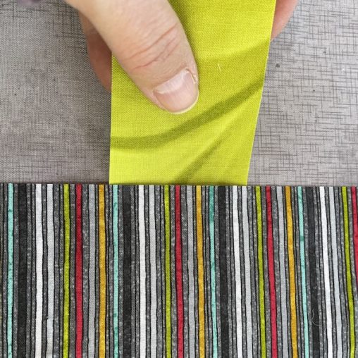 striped fabric over top of green tree trunk fabric