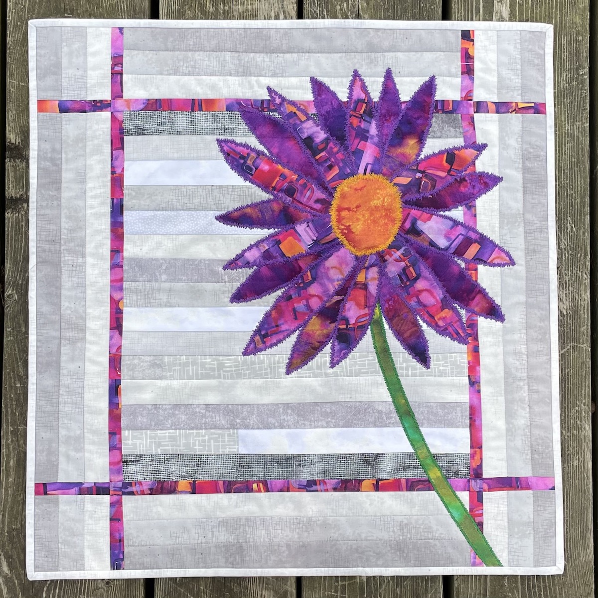 grey background with purple and orange flower