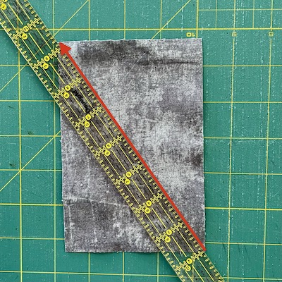 red arrow and ruler on grey fabric on a green mat