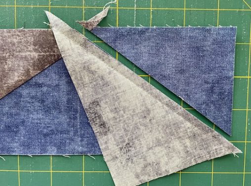 blue triangle beside grey triangle on green mat
