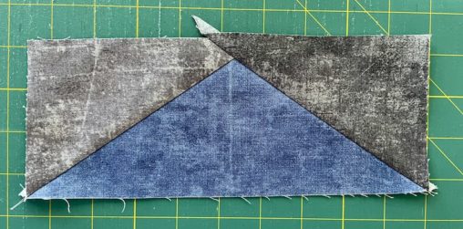 blue triangle with two grey triangles on a green mat