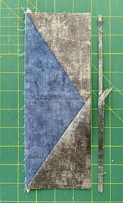 grey piece of fabric by blue and grey block on green mat