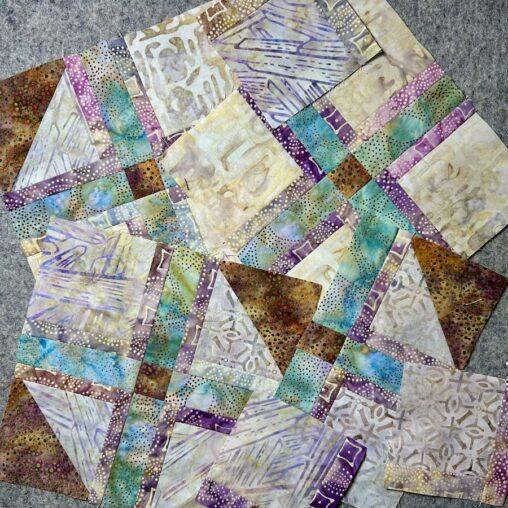 Brown, teal, purple and cream fabrics sewn into blocks