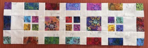 variety of colourful squares and rectangles between white sashing fabric